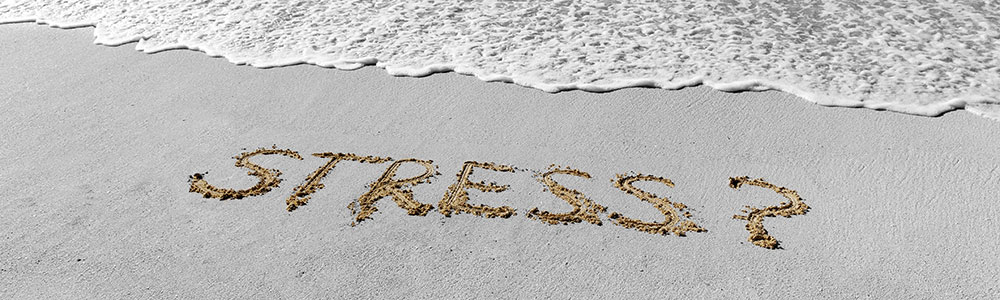 stress skrevet i sandet på stranden